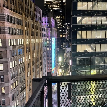 a night view of midtown Manhattan from a balcony.